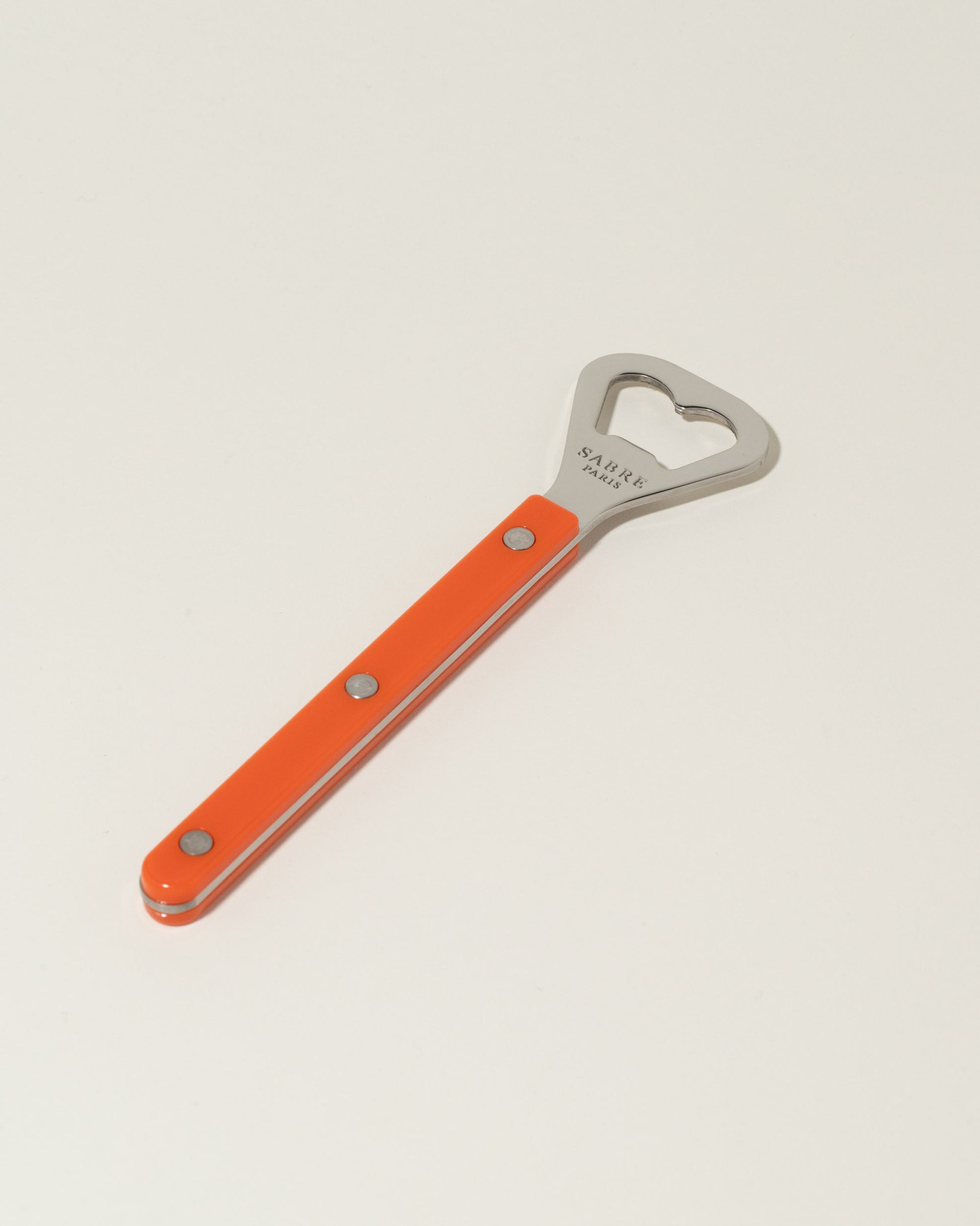 Sabre Paris Orange Bottle Opener on light color background.