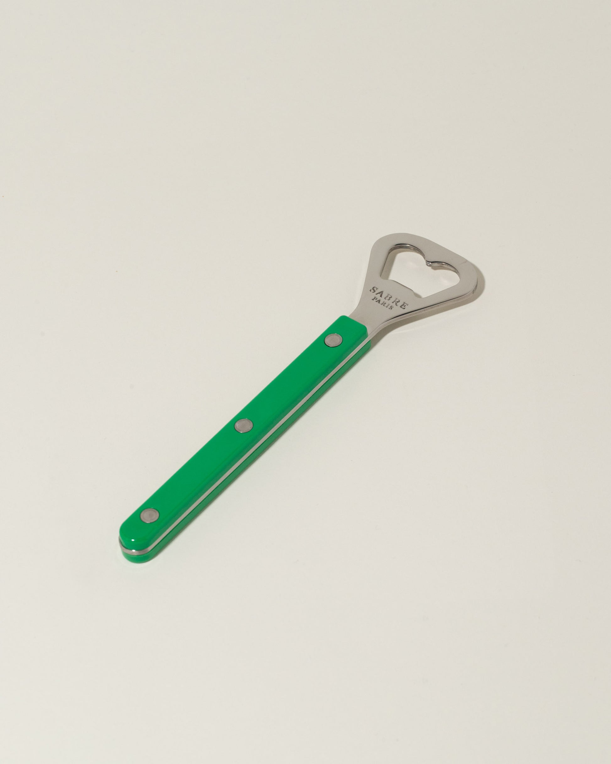 Sabre Paris Garden Green Bottle Opener on light color background.