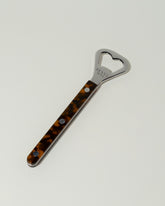 Sabre Paris Faux Tortoise Bottle Opener on light color background.