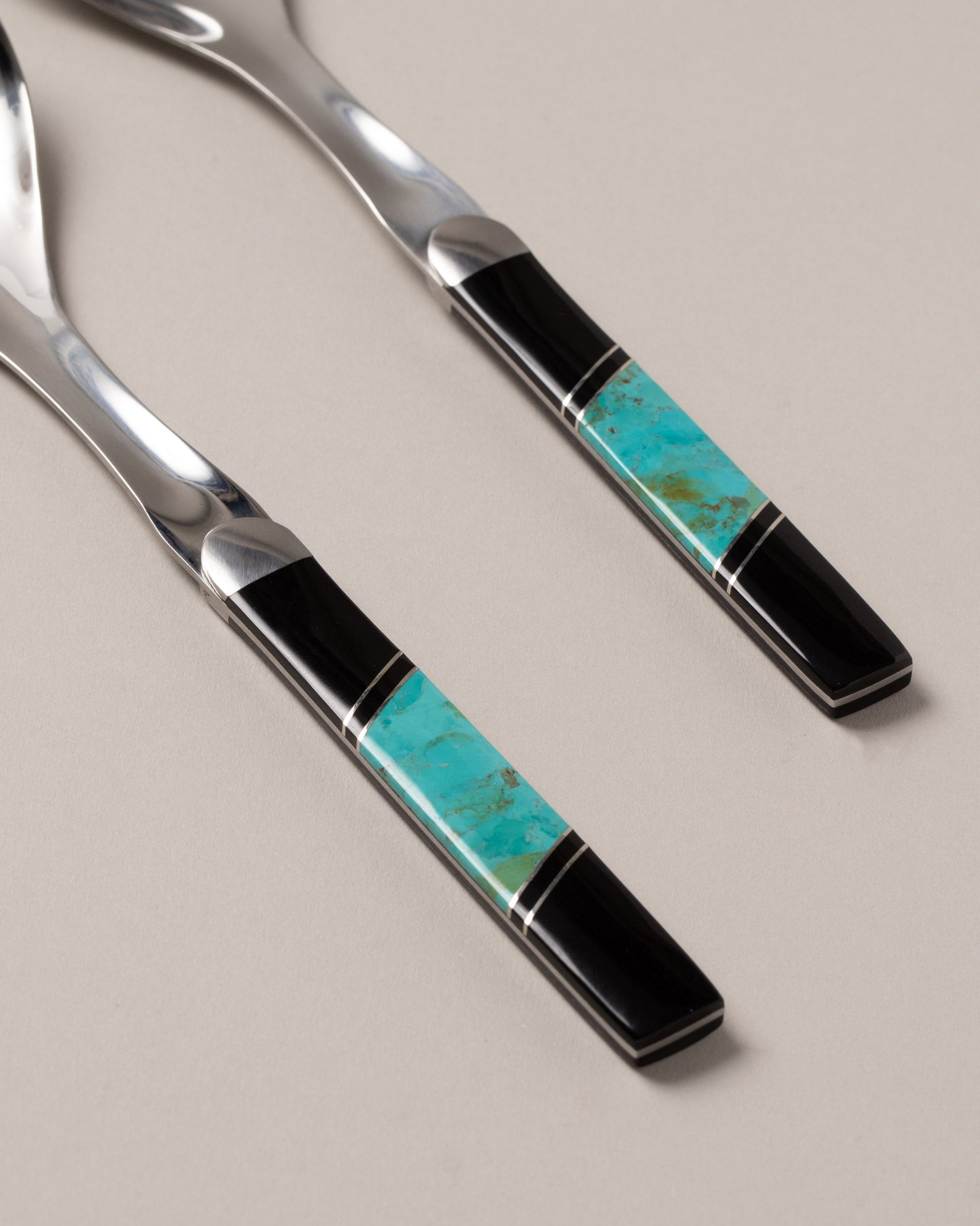 Closeup details of the Santa Fe Stoneworks Jet and Turquoise Salad Serving Set on light color background.