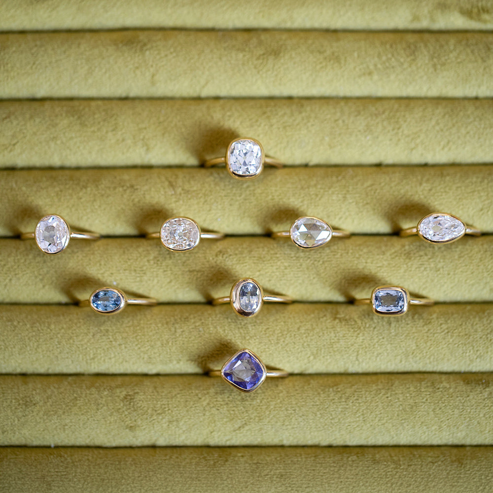 Suite of one-of-a-kind rings by Caitlin Mociun in chartreuse green velvet ring tray.