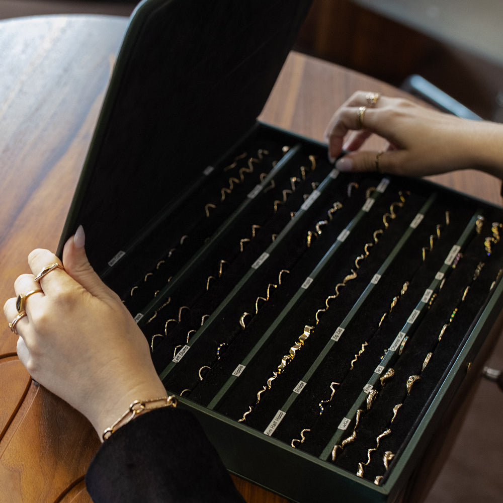 Closeup view of a Fine Jewelry Specialist showcasing a jewelry tray of Mociun wedding bands.