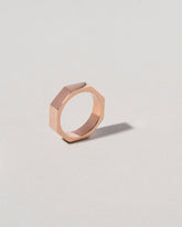 View from the side of the Rose Gold 4mm Single Stone Segmented Band on light color background.