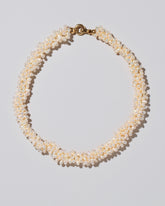 Fold Over Toggle Clasp Braided Zipper Pearl Collar Necklace on light color background.