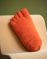 Styled image featuring the Sohn Persimmon Chenille Soft Sculpture Foot Pillow.