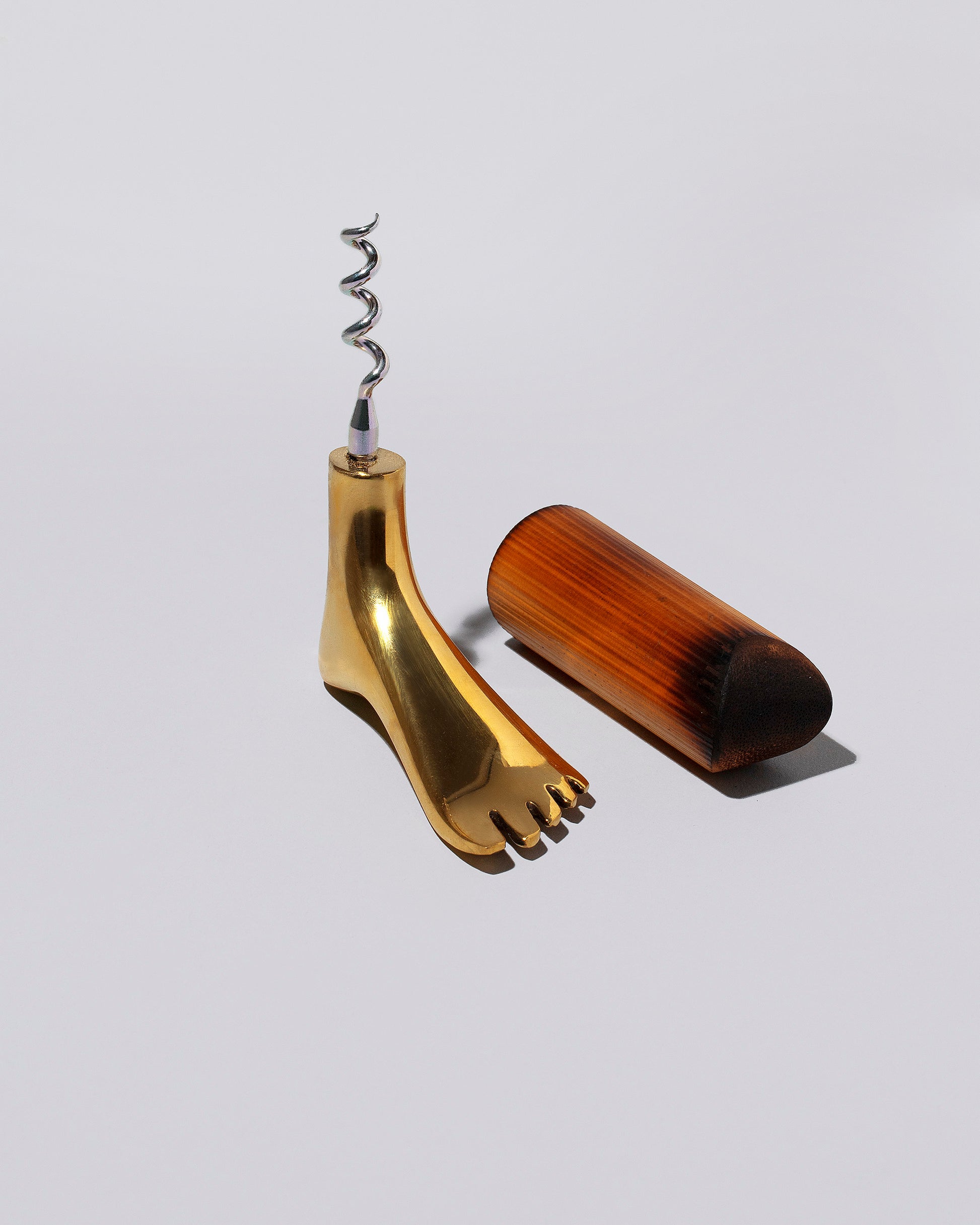 Detail view of the Carl Auböck Brass Foot Corkscrew on light color background.