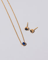 Sapphire Sun & Moon Necklace & Studs Set on light color background.