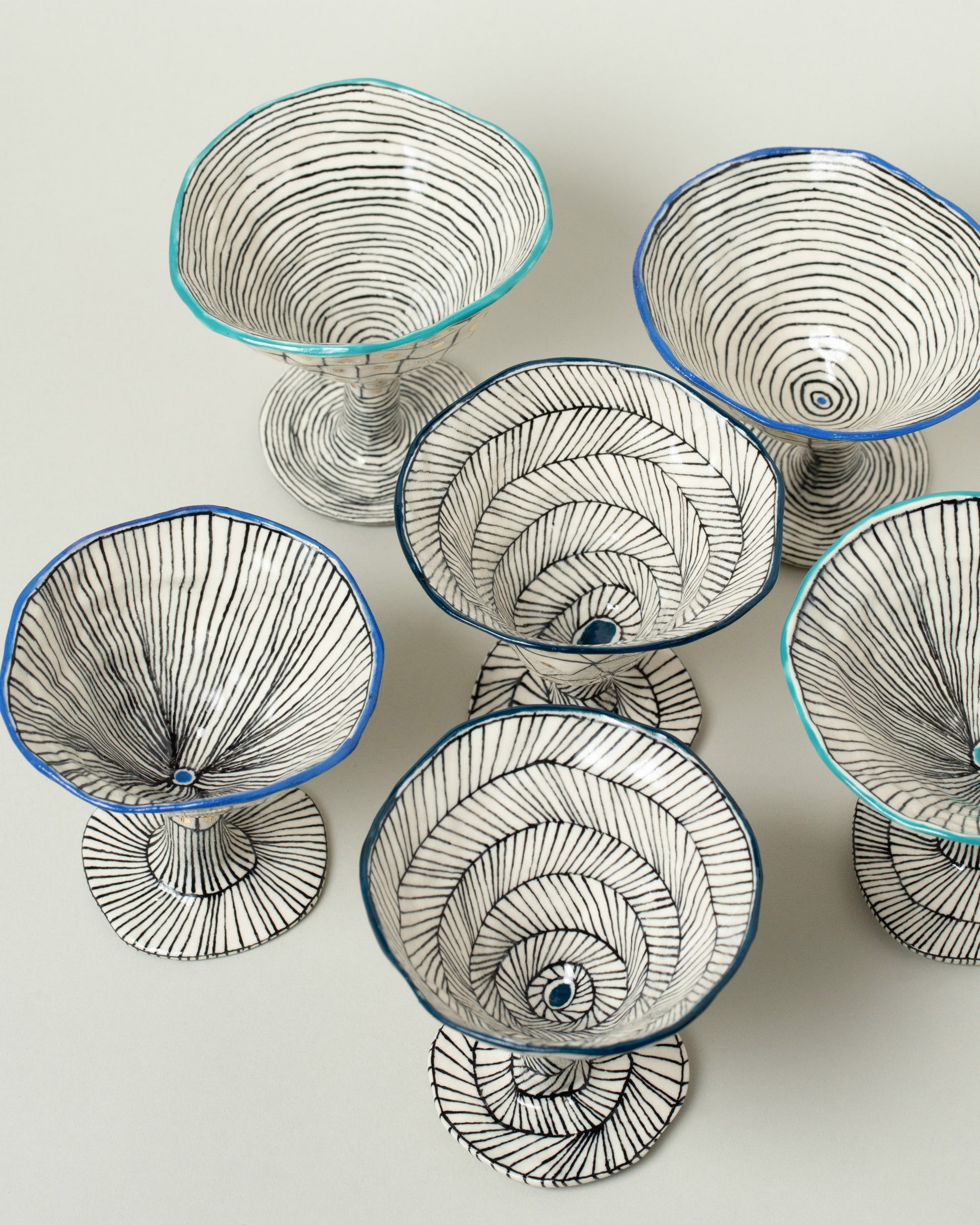 Closeup details of the Suzanne Sullivan Cobalt, Midnight and Teal For Your Pleasure Martini Glasses on light color background.