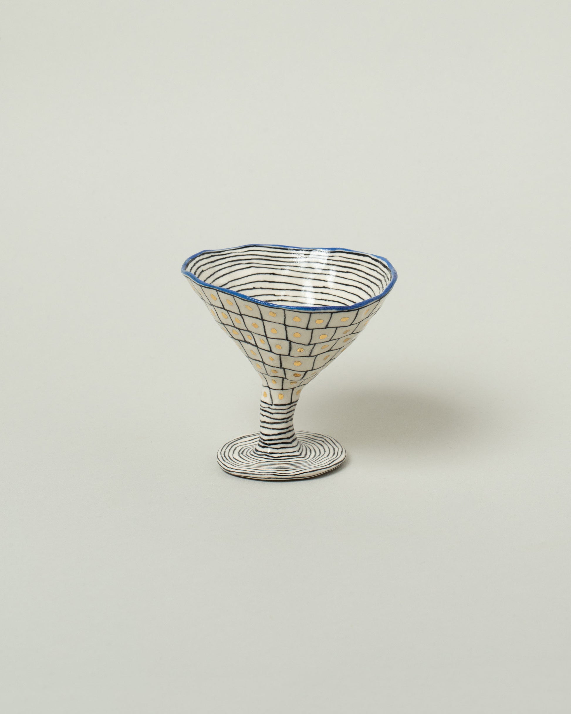 Suzanne Sullivan Cobalt One For Your Pleasure Martini Glass on light color background.