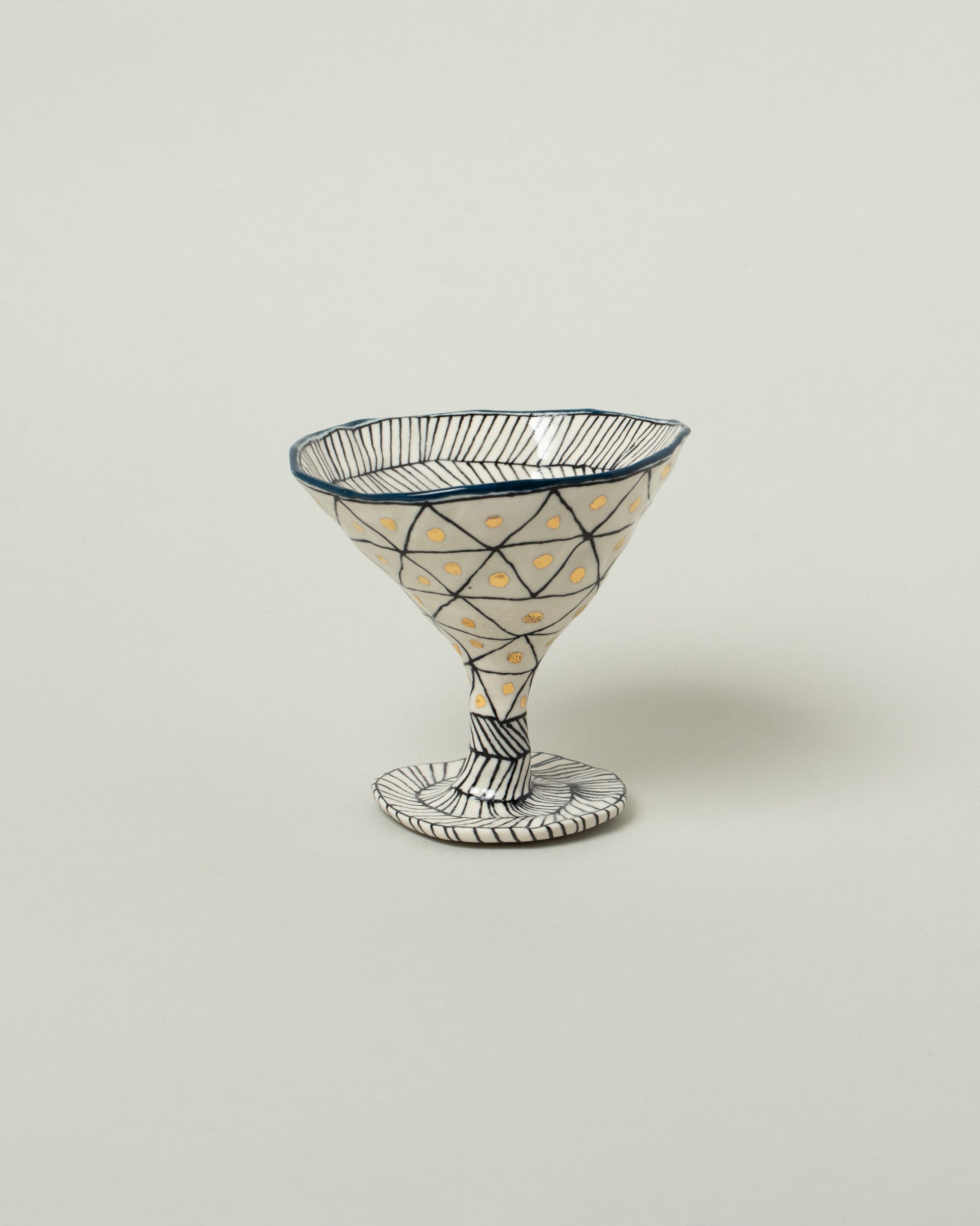 Suzanne Sullivan Midnight One For Your Pleasure Martini Glass on light color background.