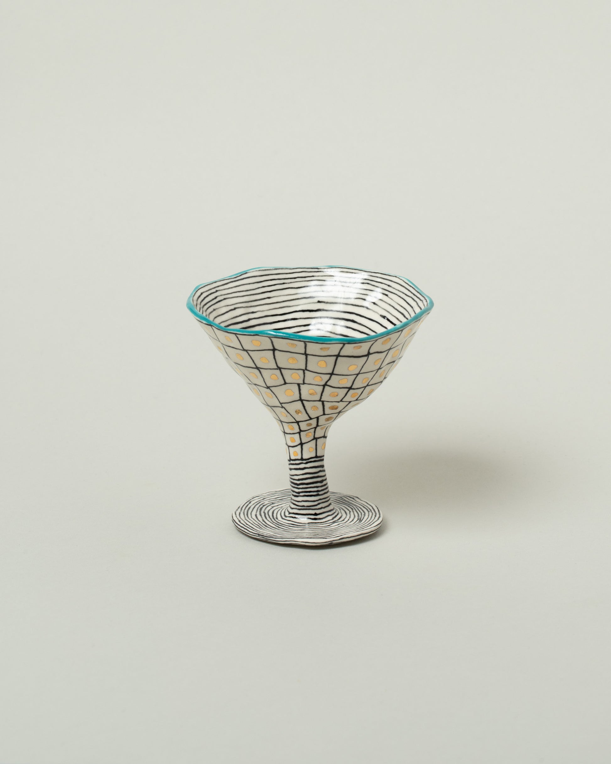 Suzanne Sullivan Teal One For Your Pleasure Martini Glass on light color background.