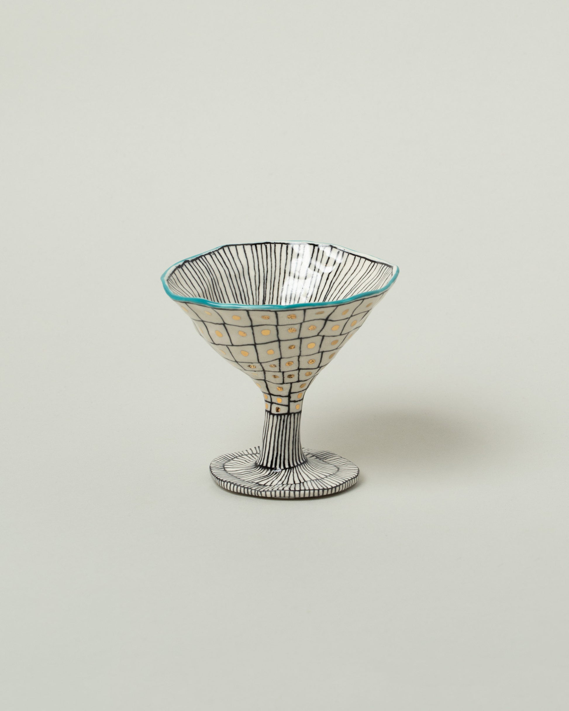 Suzanne Sullivan Teal Two For Your Pleasure Martini Glass on light color background.