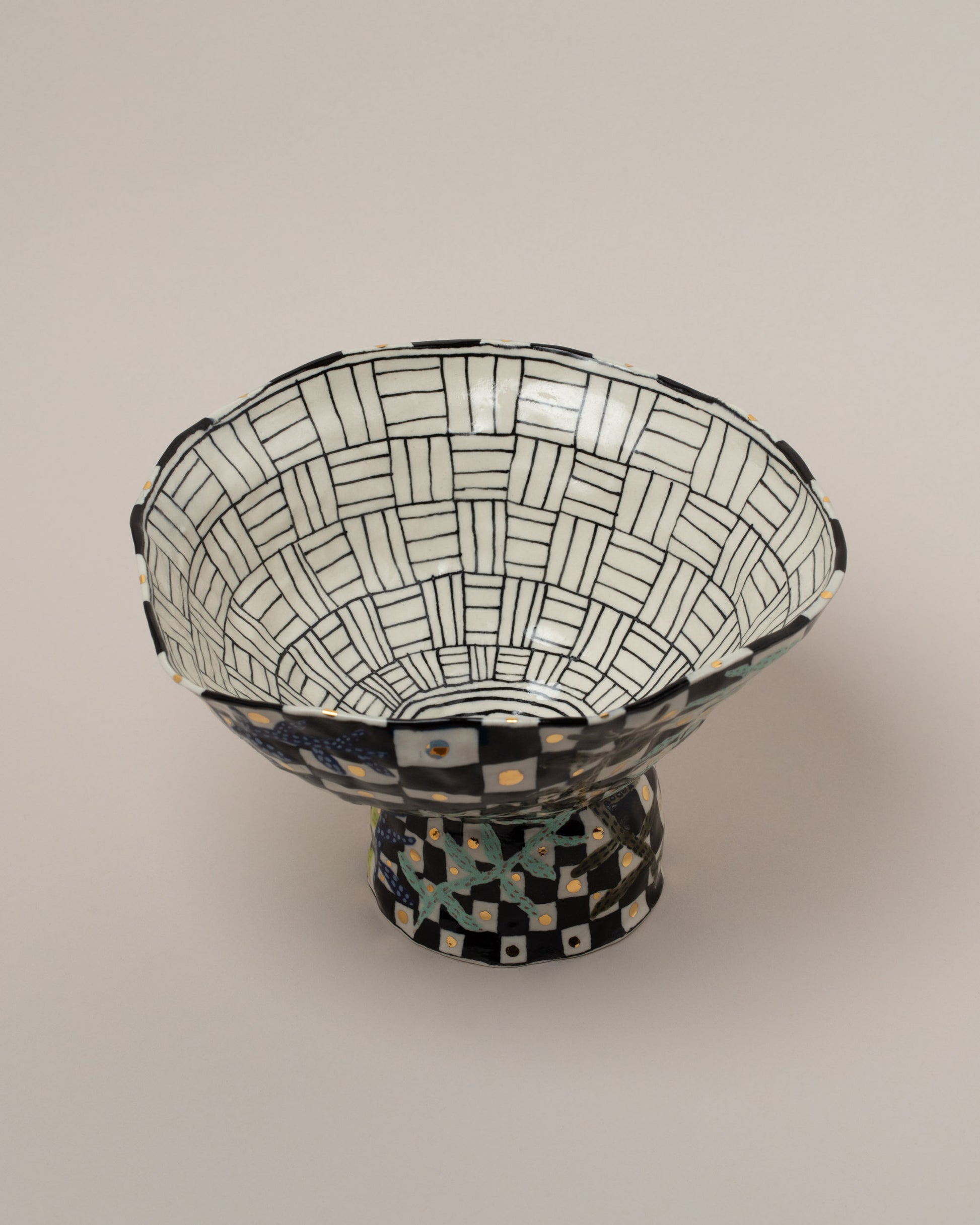 Closeup details of the Suzanne Sullivan Answers To Questions Footed Bowl on light color background.