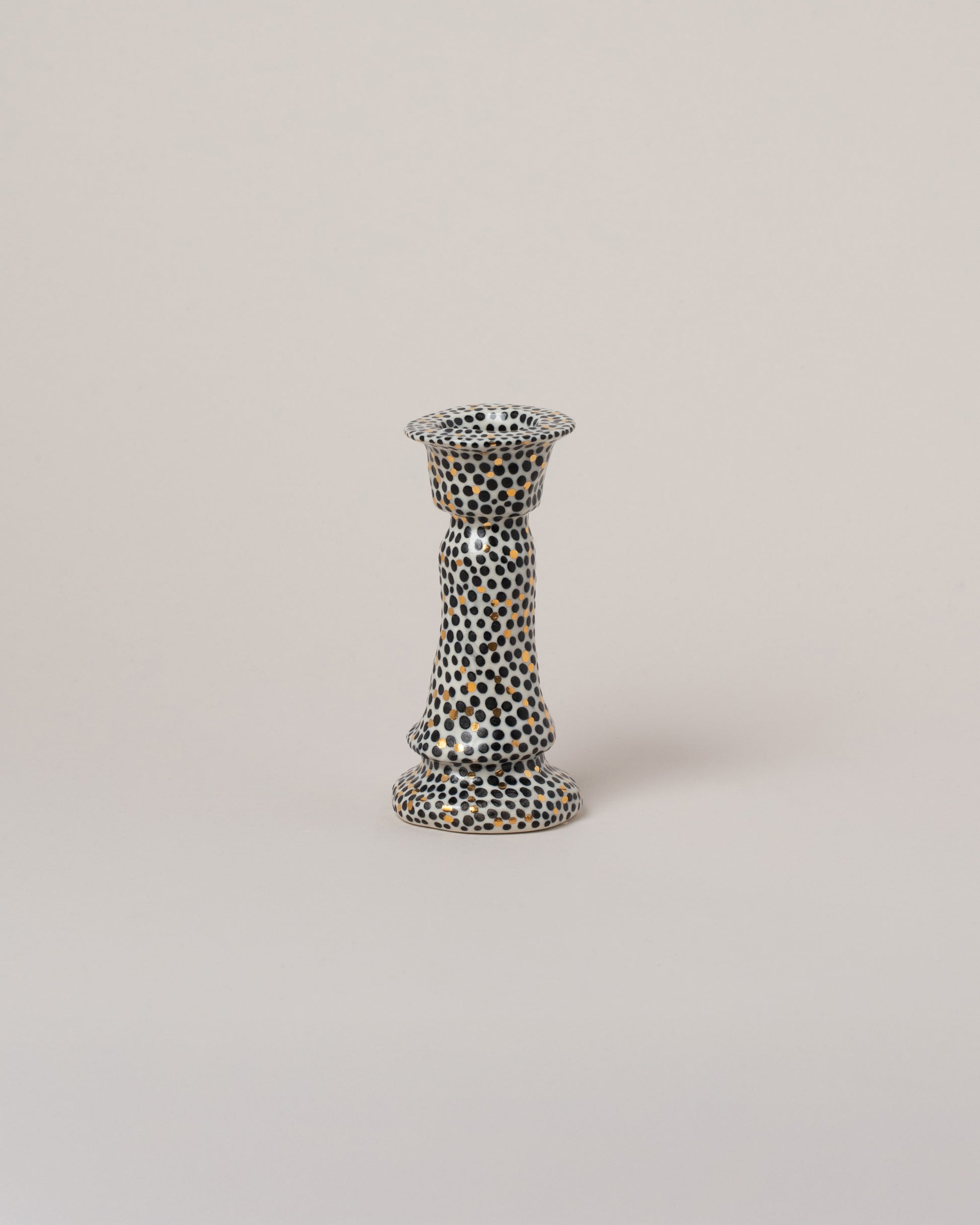 Suzanne Sullivan Bare Essential Meaning Candlestick on light color background.