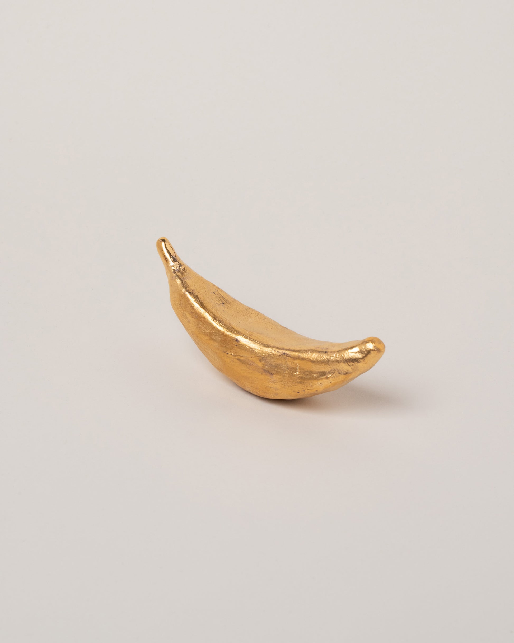 Suzanne Sullivan Gold Banana on light color background.