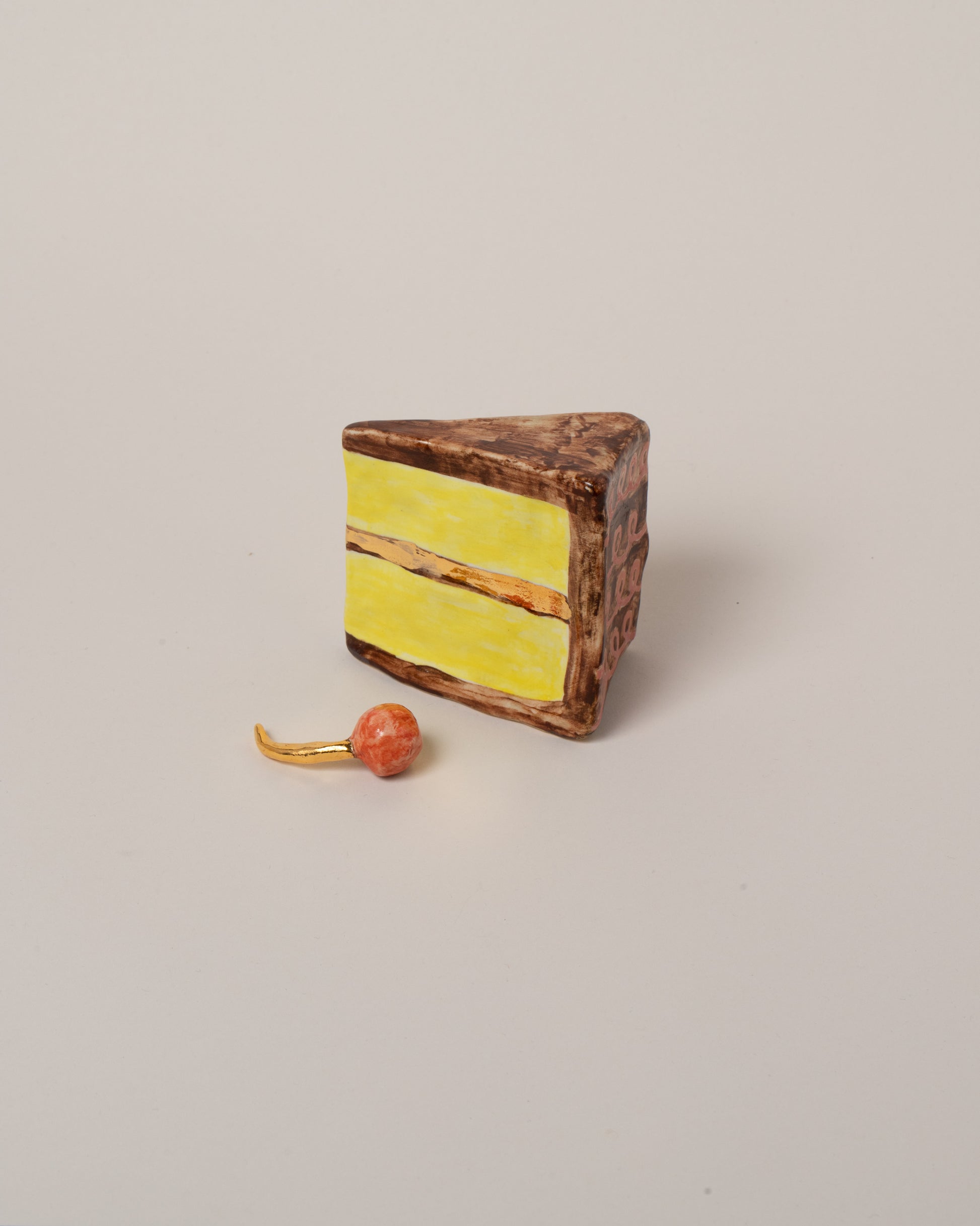 View from the back of the Suzanne Sullivan Piece Of Cake & Cherry Not On Top on light color background.