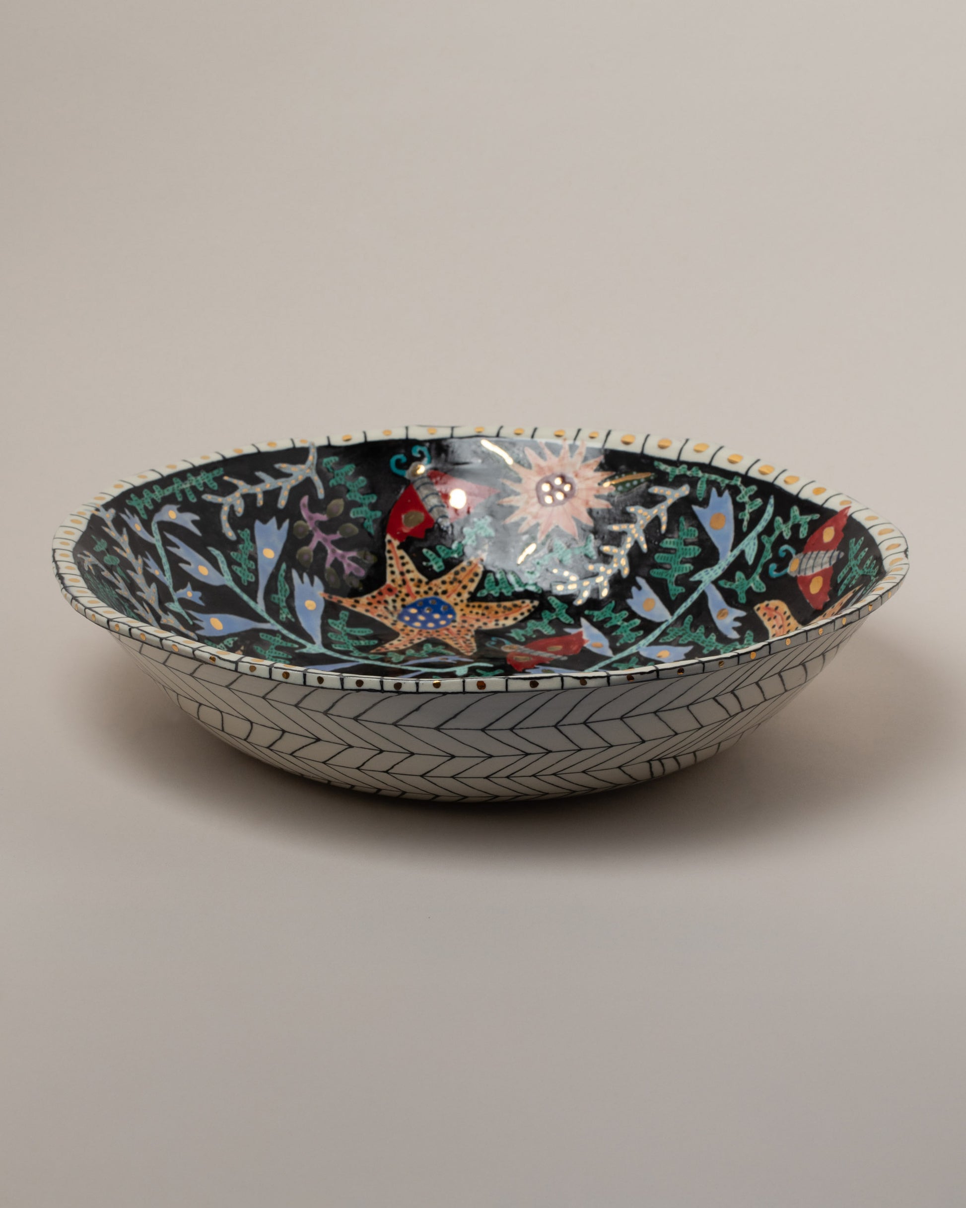Suzanne Sullivan So Well & Merrily Serving Bowl on light color background.