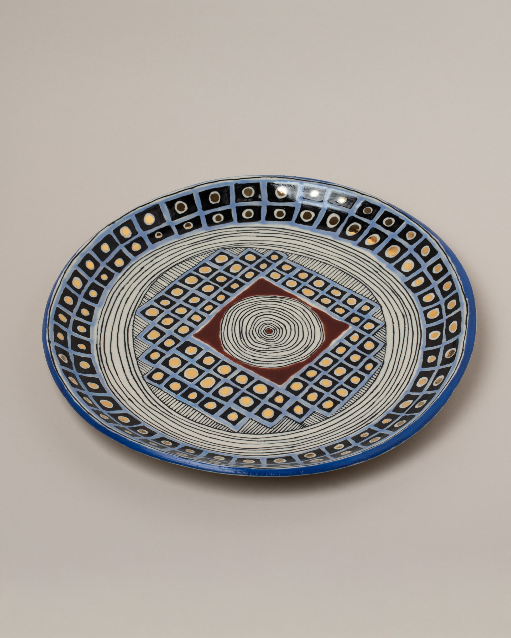 Closeup details of the Suzanne Sullivan Well Deserving Of Esteem Round Platter on light color background.