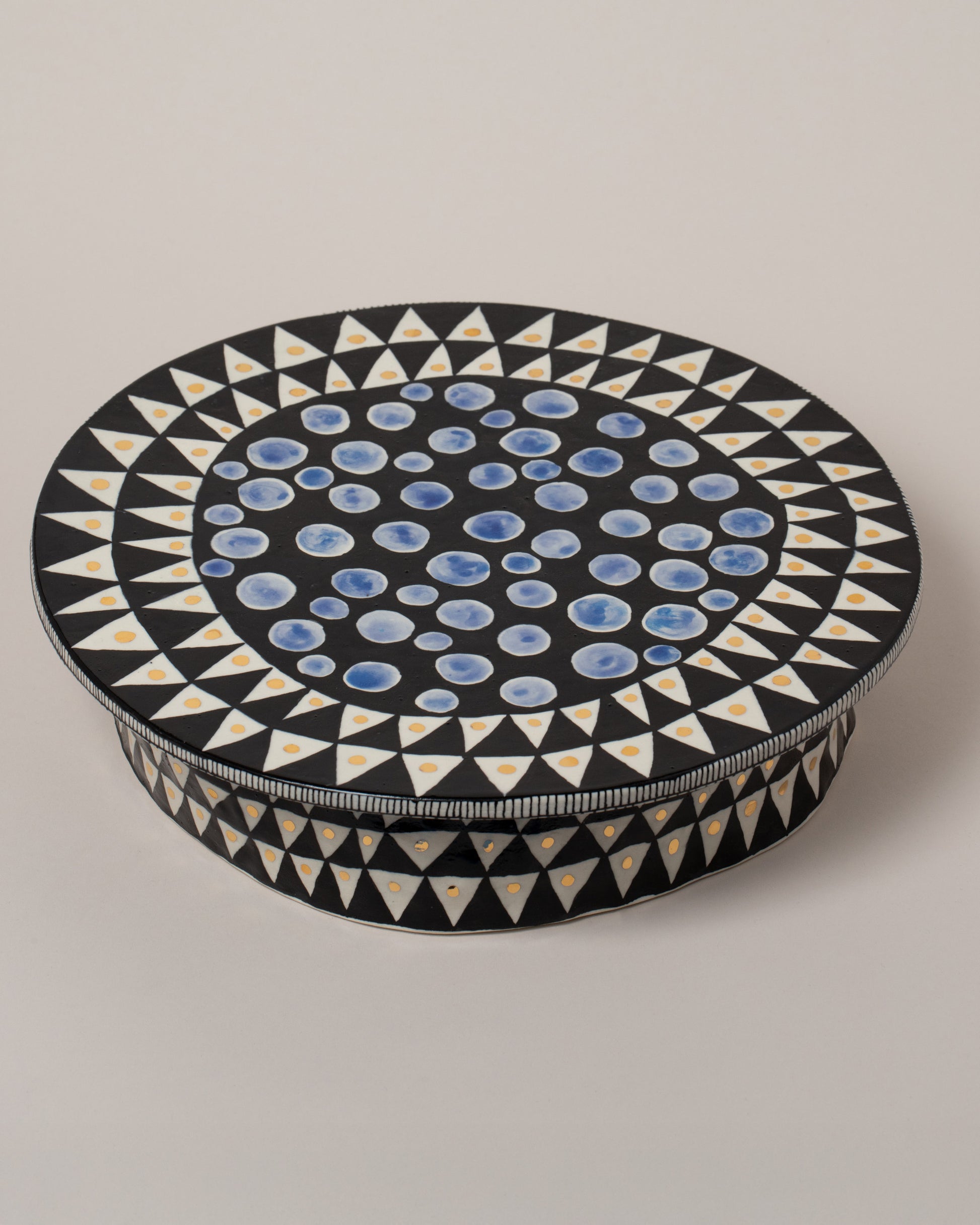 Closeup details of the Suzanne Sullivan You'll Have To Distort It Cake Stand on light color background.