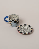 Suzanne Sullivan Four A Long Story Short Espresso Cup & Saucer on light color background.