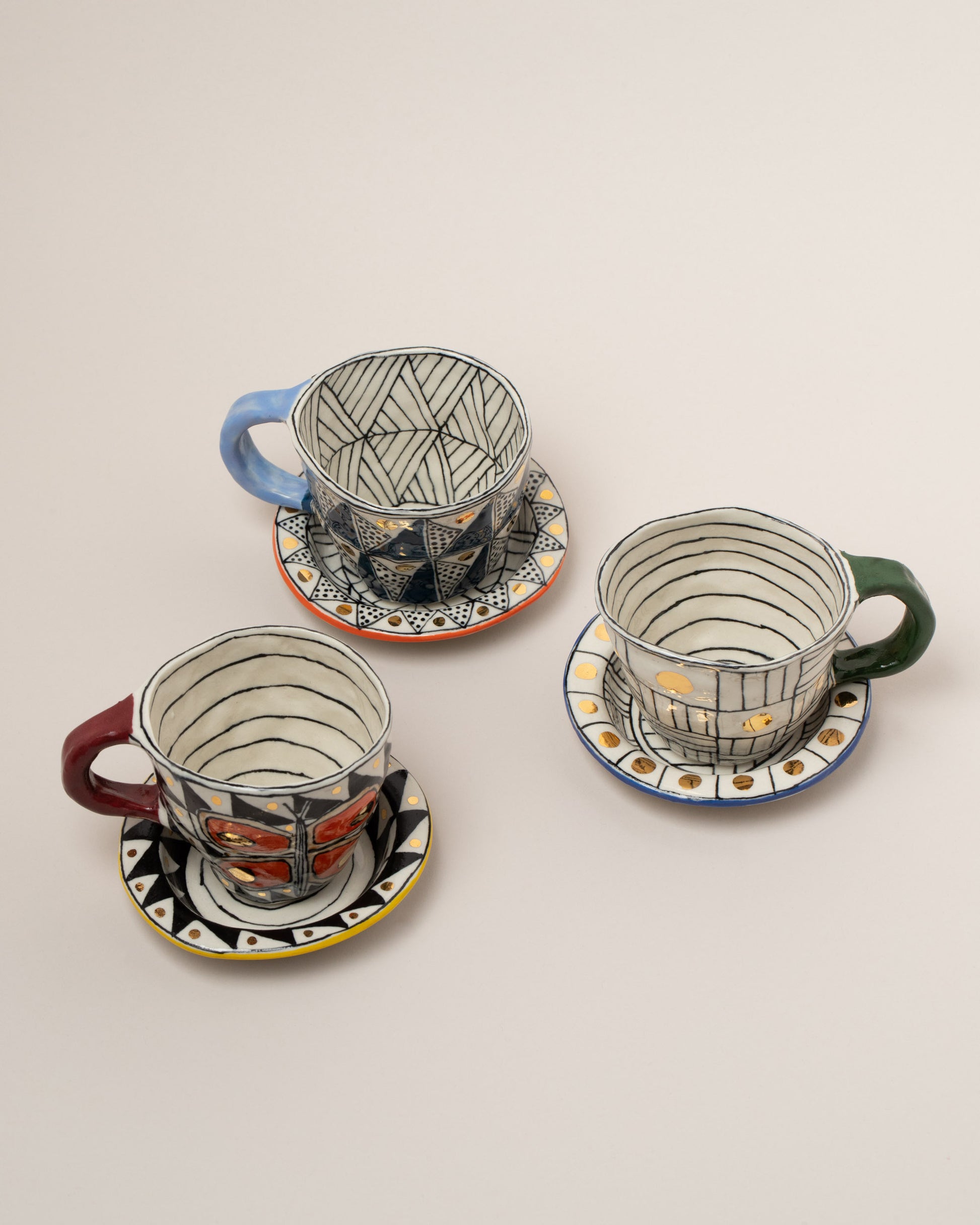 Suzanne Sullivan Two A Long Story Short Espresso Cup & Saucer sets on light color background.