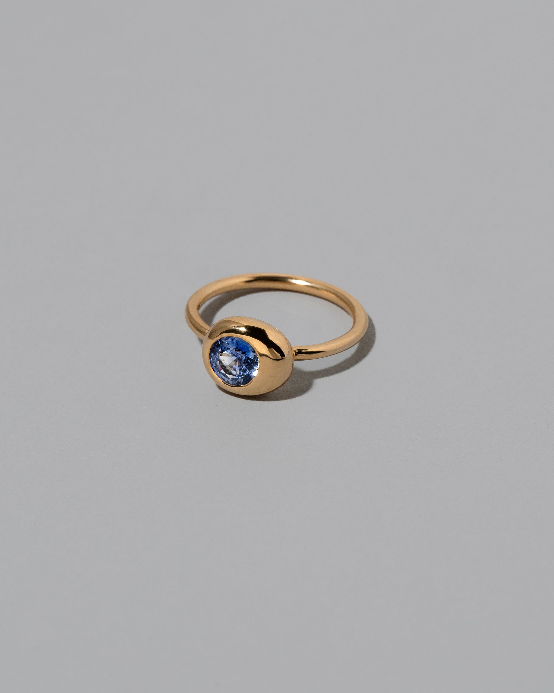 View from the side of the Blue Sapphire Level Ring on light color background.