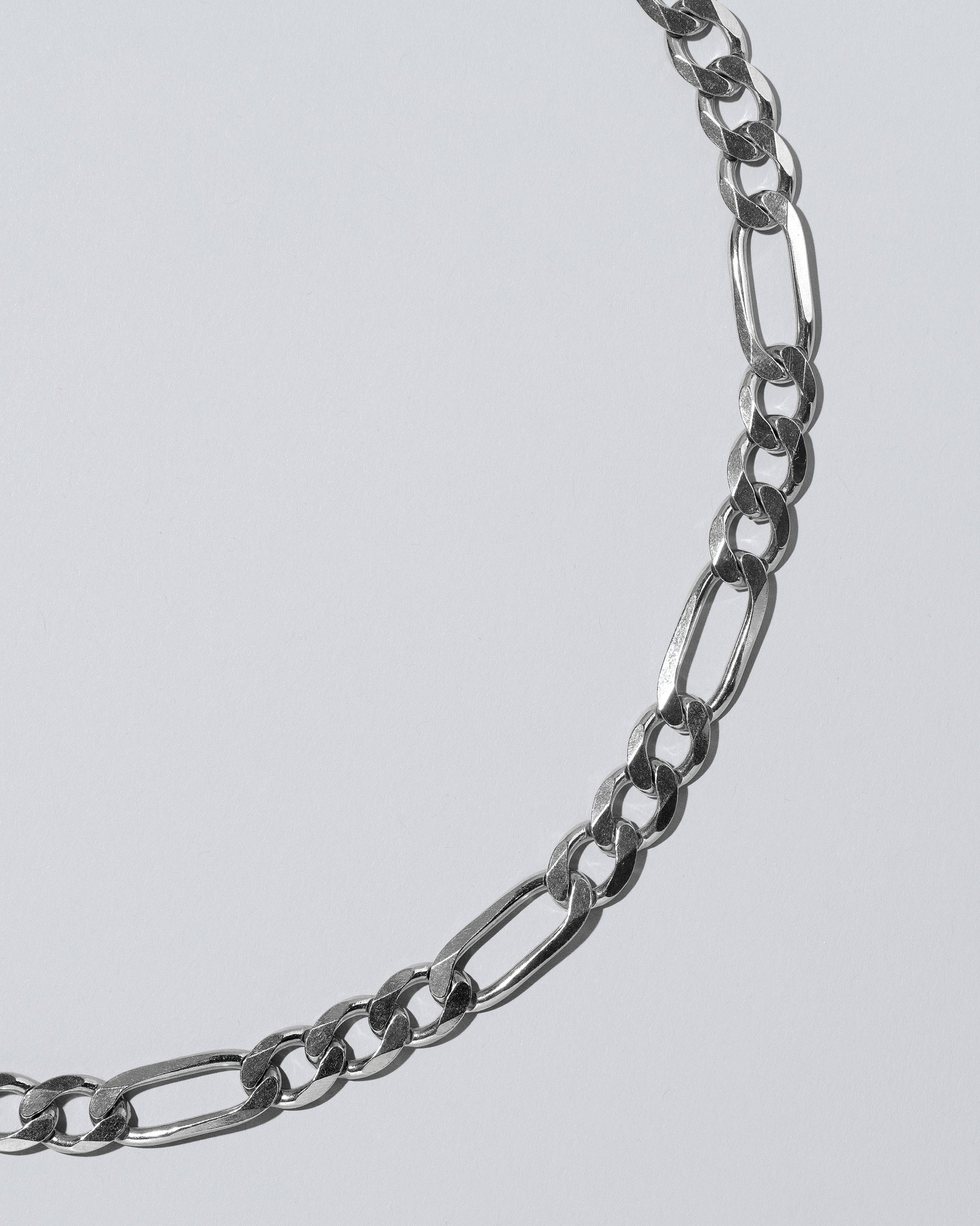 Silver Figaro Chain on light color background.