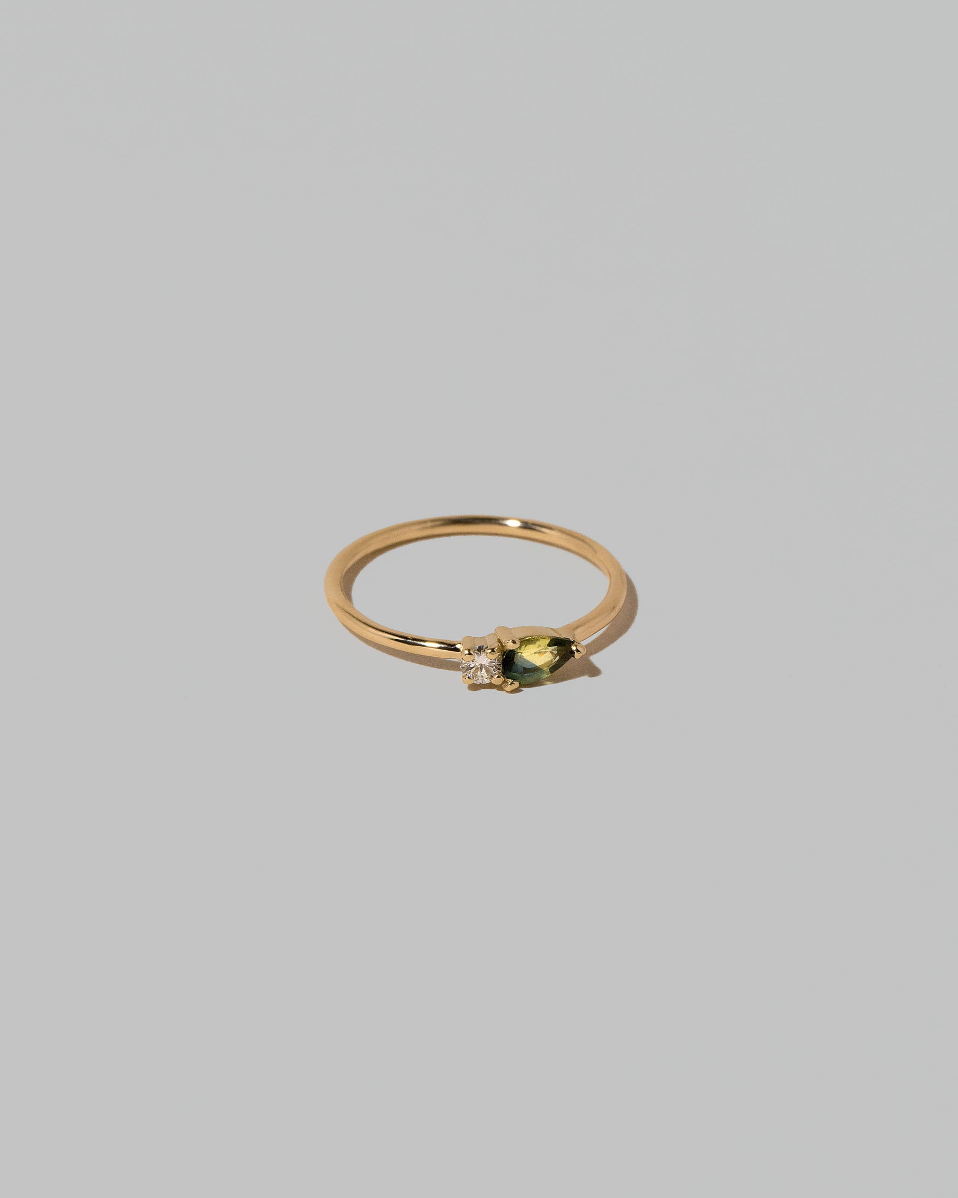 View from the side of the Bicolor Sapphire Teardrops Ring on light color background.