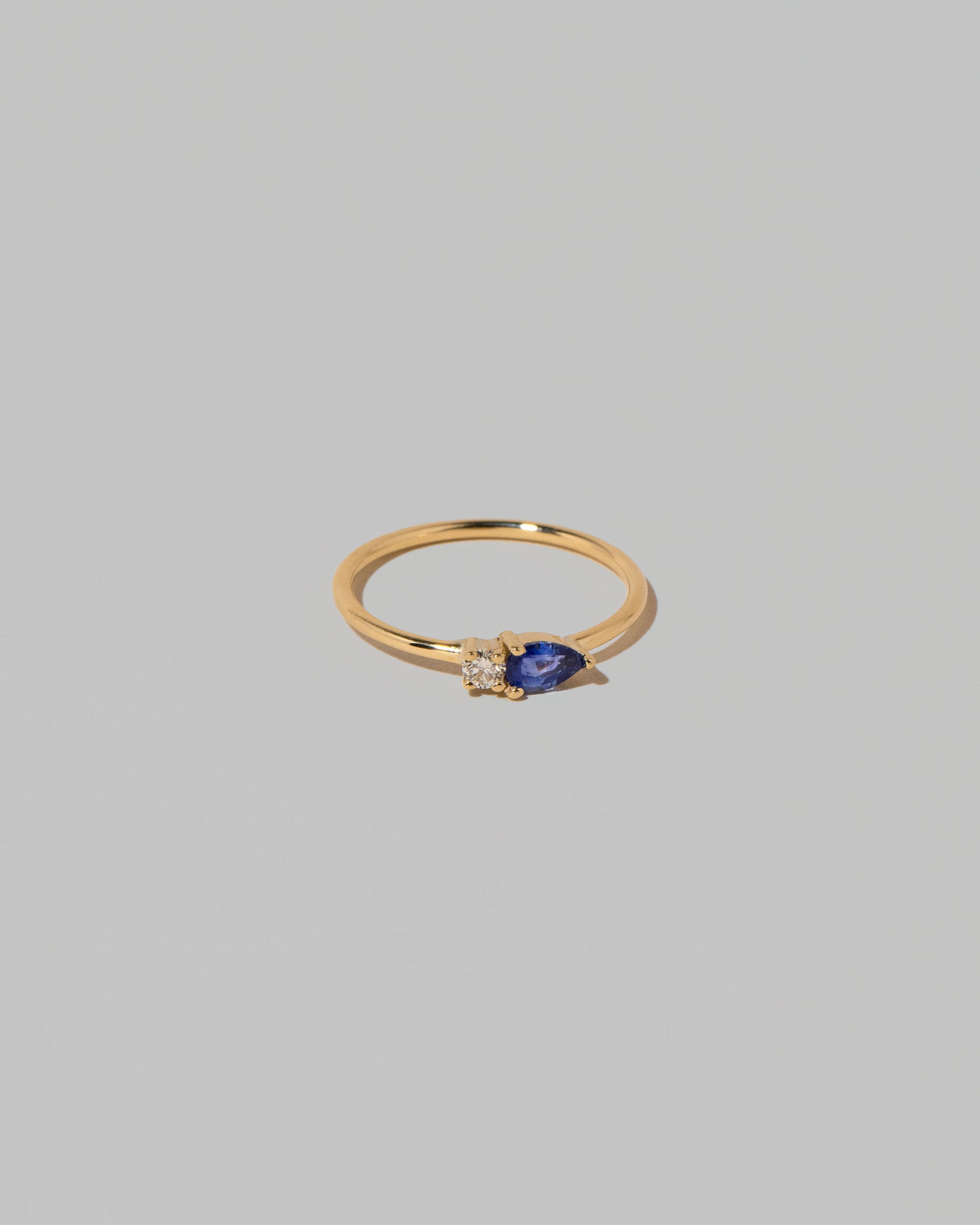 View from the side of the Blue Sapphire Teardrops Ring on light color background.