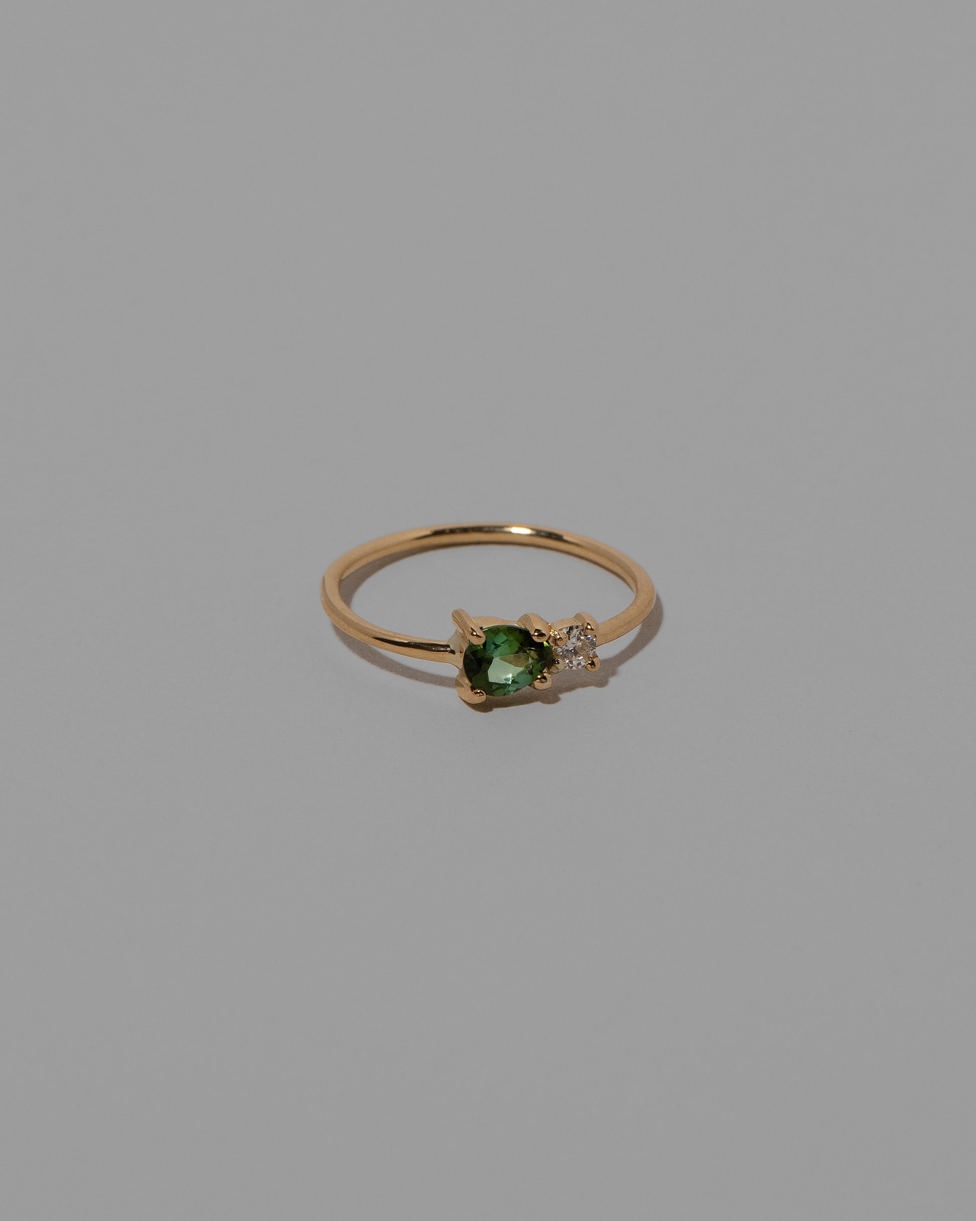 View from the side of the Green Sapphire Teardrop Ring on light color background.