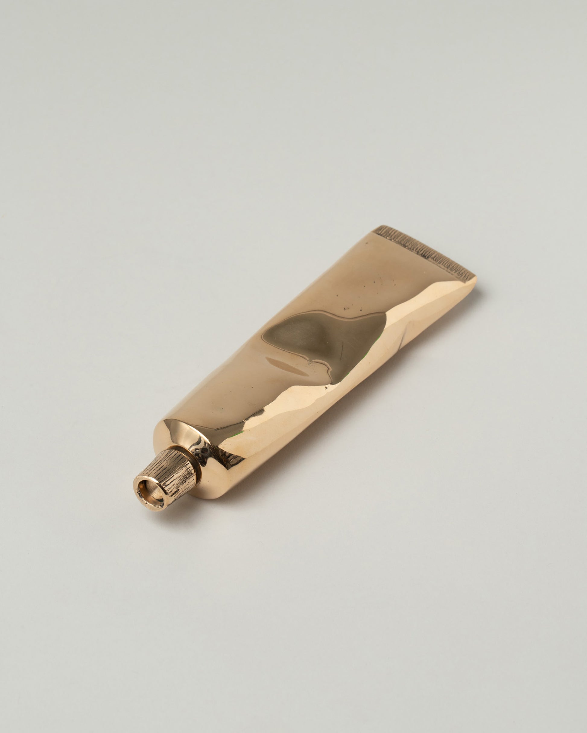 Pearce Objects Cast Bronze Toothpaste Tube on light color background.