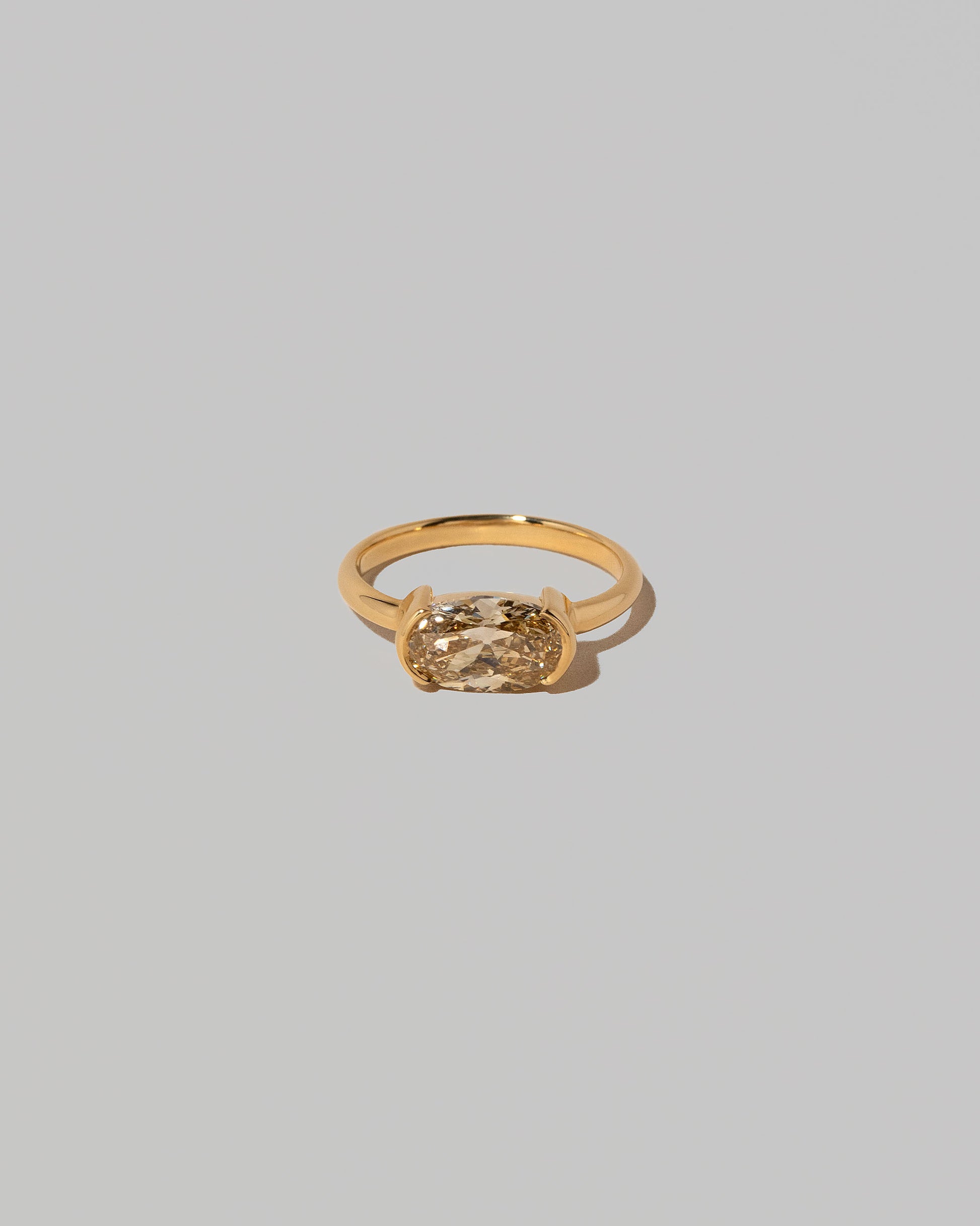 Oval Brown Diamond Transformation Ring on light color background.