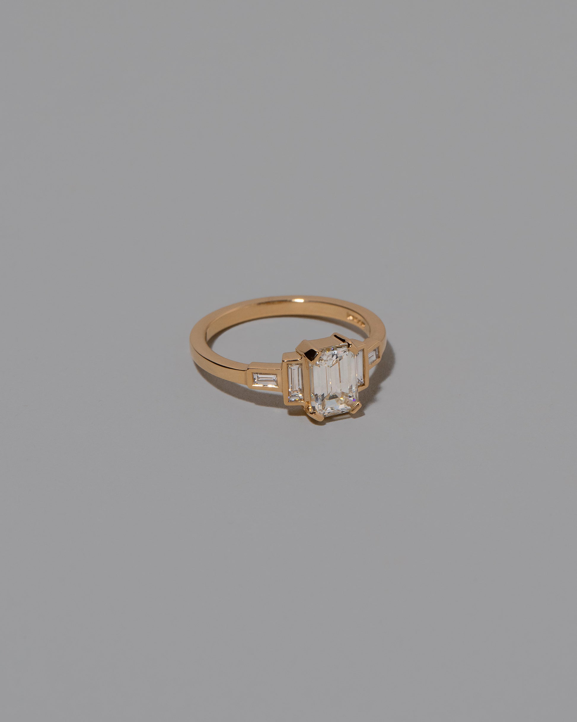 View from the side of the Diamond Assertion Ring on light color background.