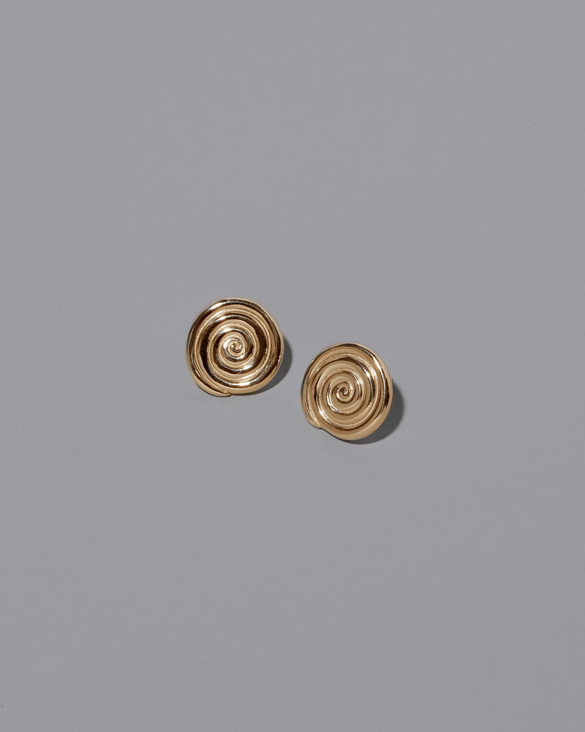 CRZM Gold Serpentinite Stud Earrings on light color background.