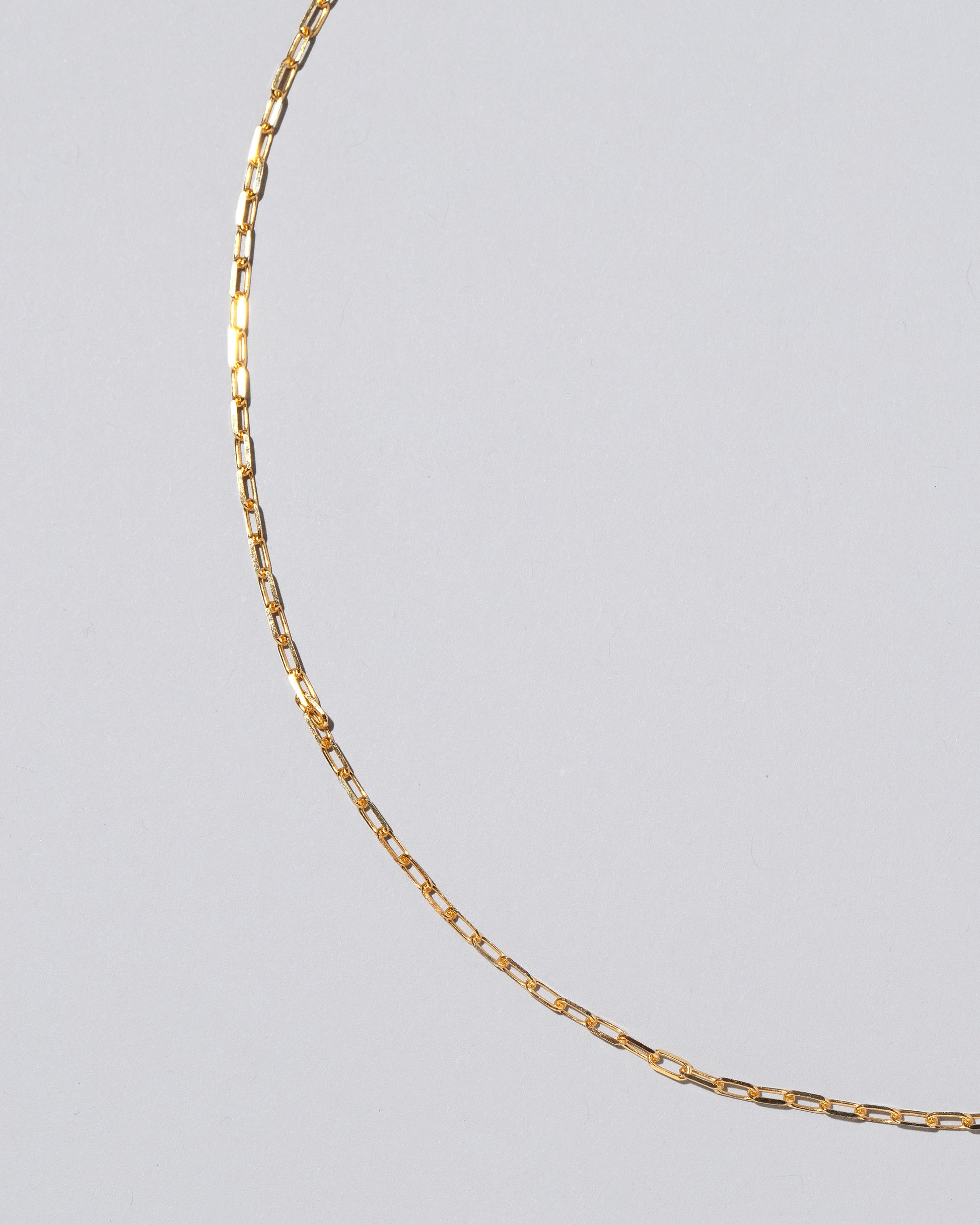 Closeup detail of the 2.2mm Lightweight Beveled Oval Chain Necklace on light color background.