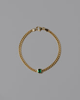 Gold Emerald Fold Bracelet on light color background.