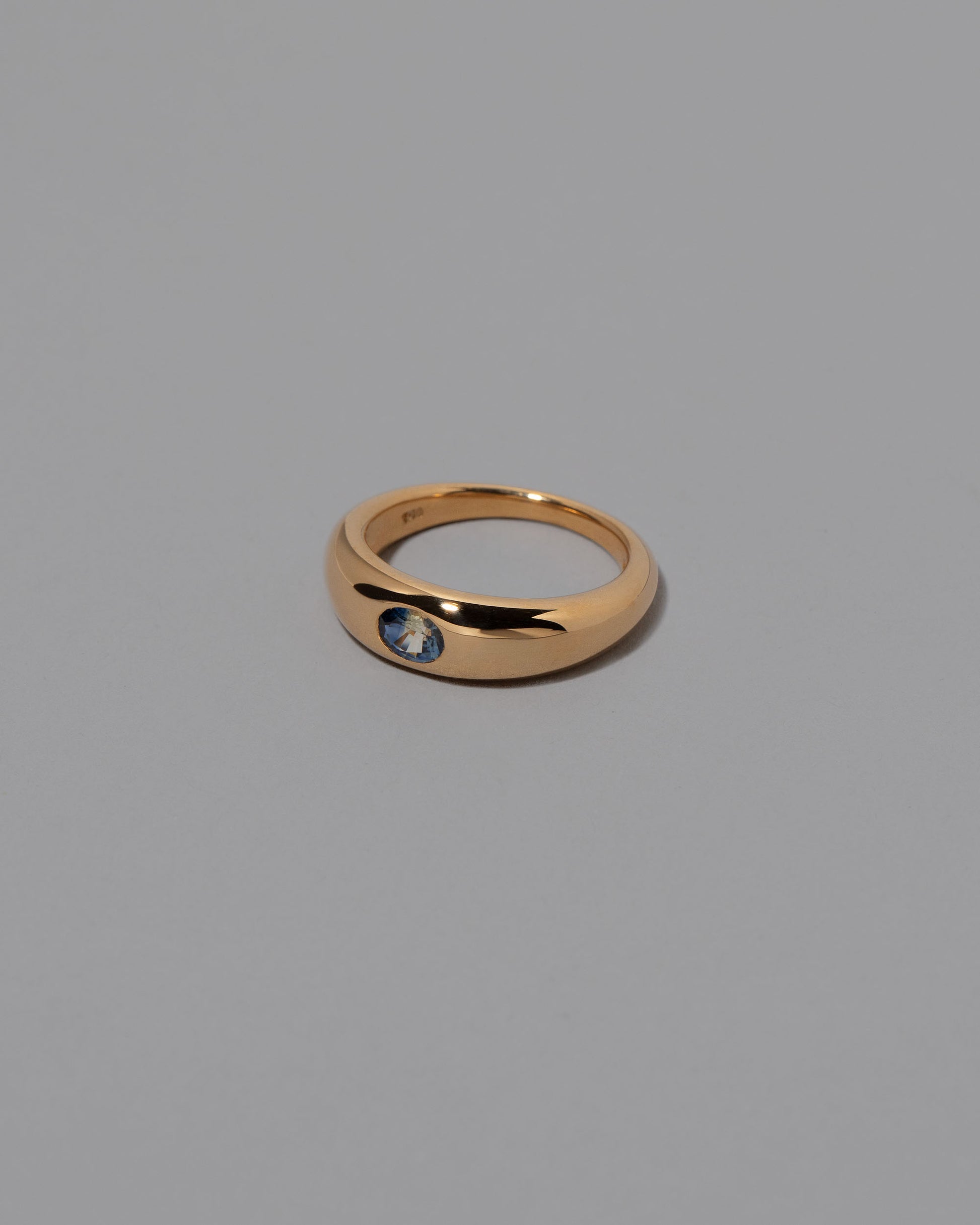 View from the side of the Bicolor Sapphire Venus Ring on grey color background.