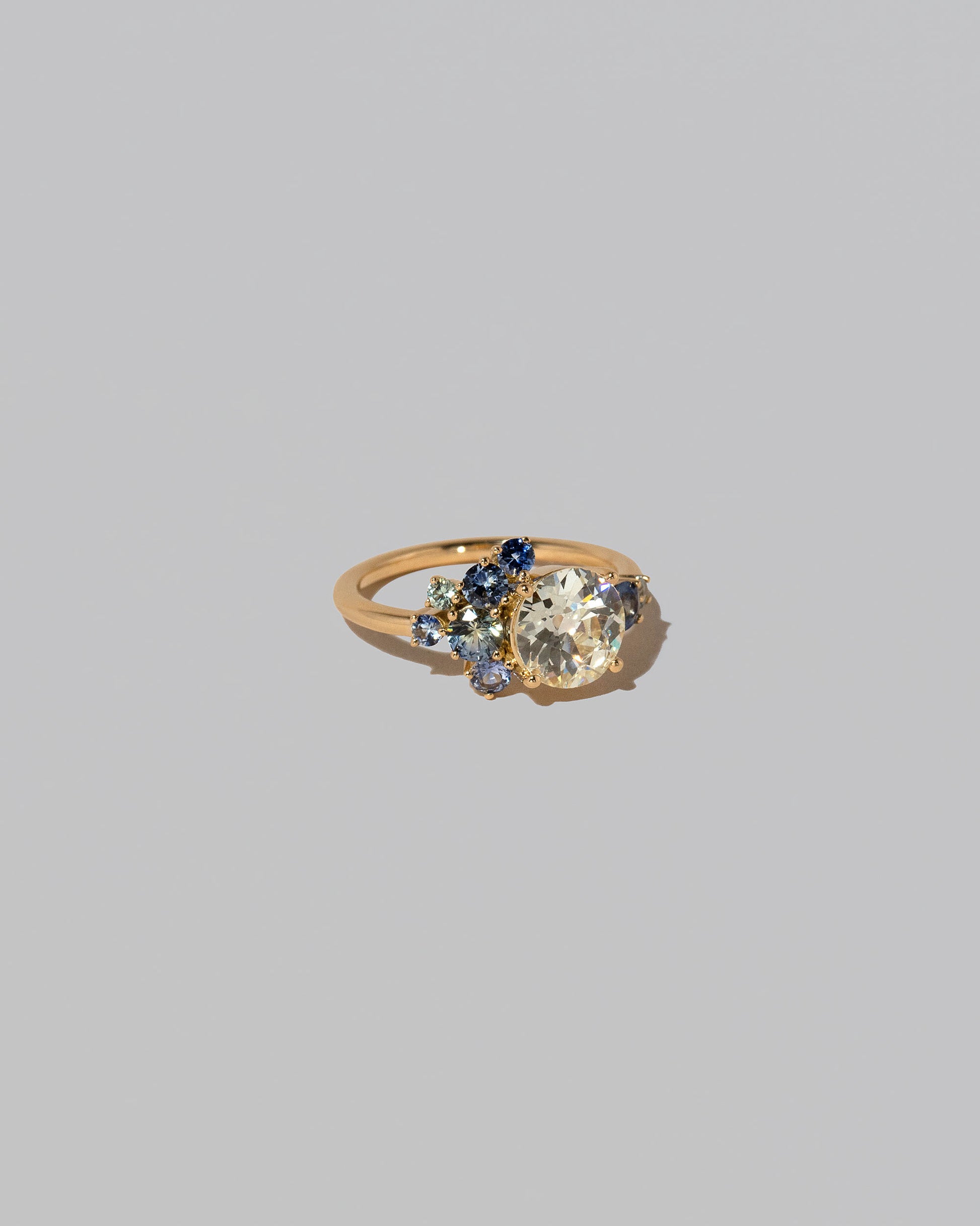 View from the side of the Diamond & Sapphire Vega Ring on light color background.