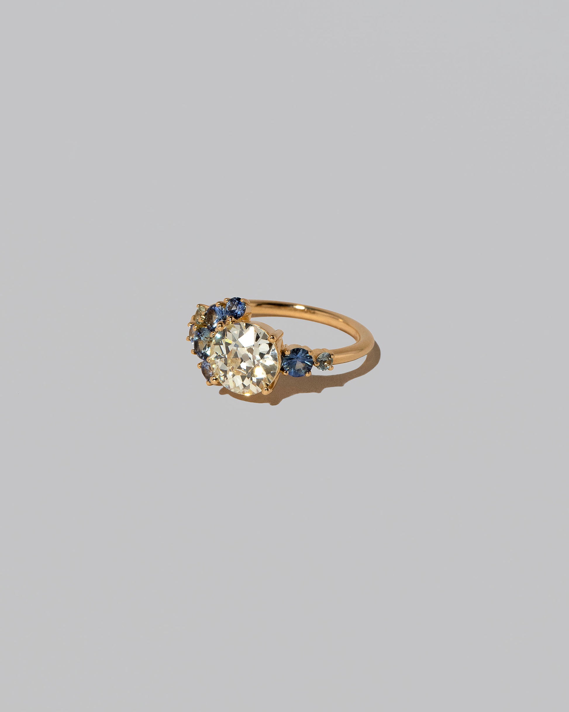 View from the side of the Diamond & Sapphire Vega Ring on light color background.
