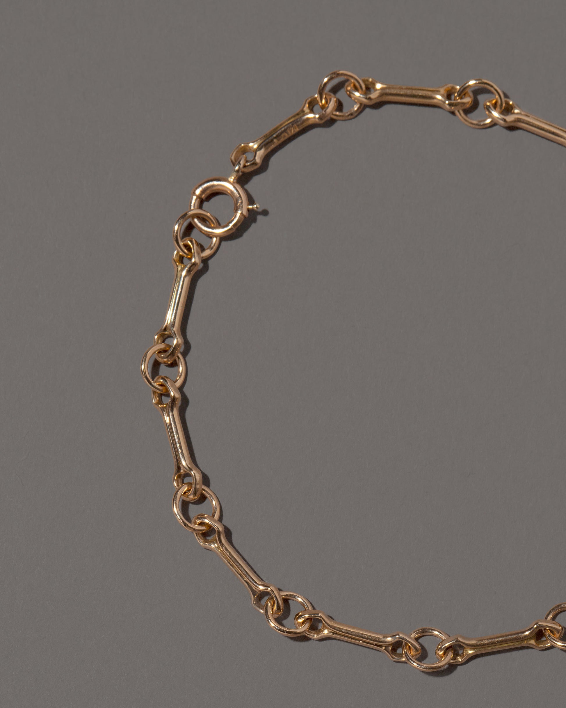 Closeup details of the Bar Link Charm Chain Bracelet on light color background.