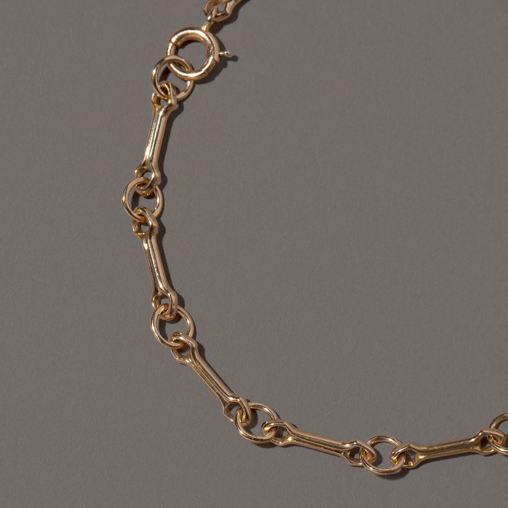 product_details::Closeup details of the Bar Link Charm Chain Bracelet on light color background.