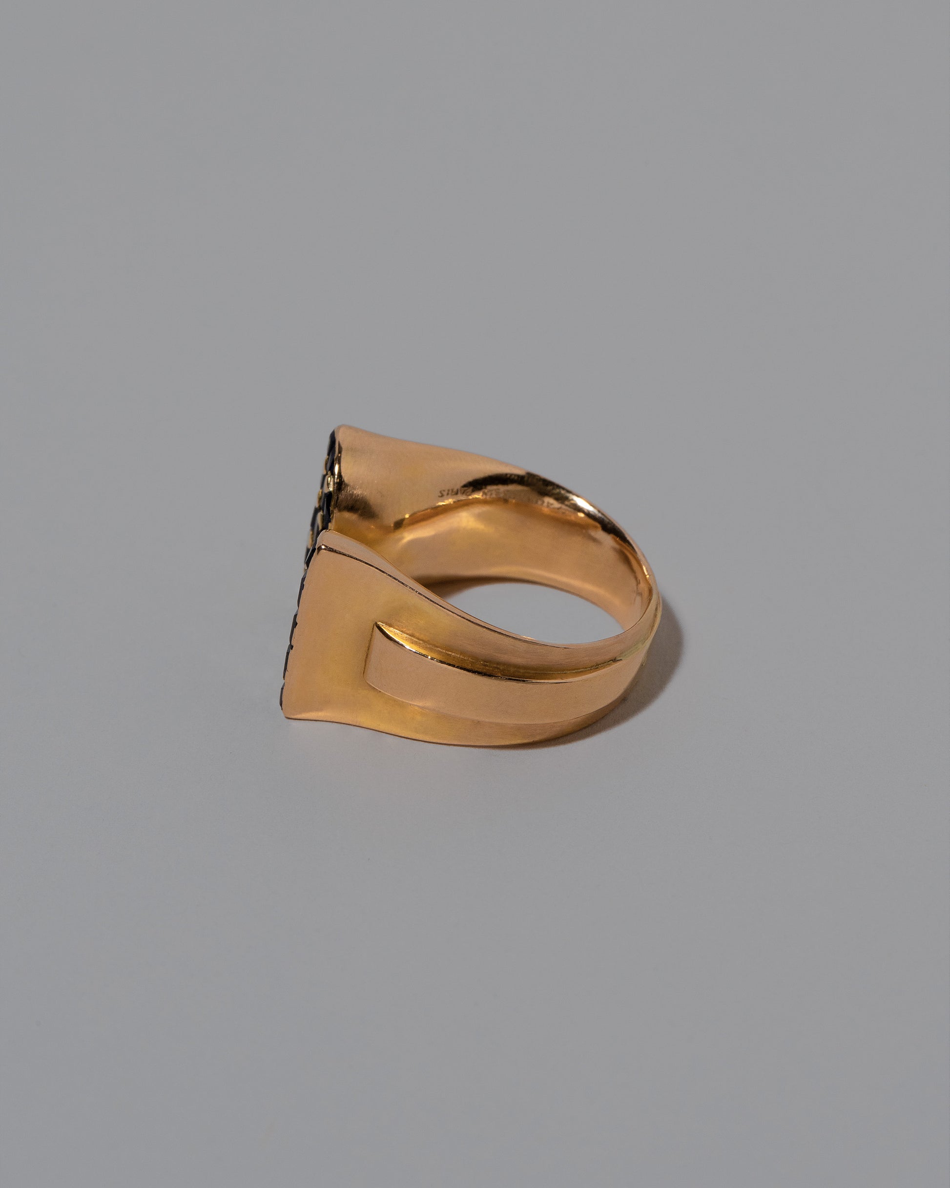 View from the side of the Vintage Mauboussin Paris Blue Sapphire Bow Ring on light color background.