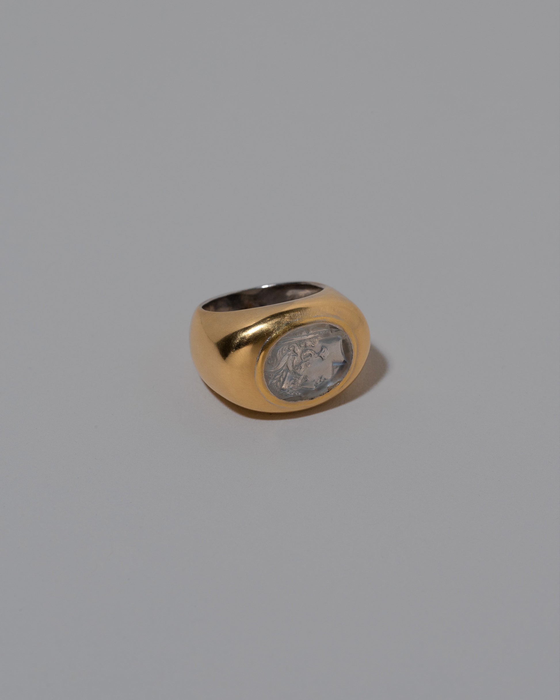 View from the side of the Vintage Moonstone Demeter Intaglio Ring on light color background.