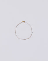 White Seed Pearl Bracelet on light color background.