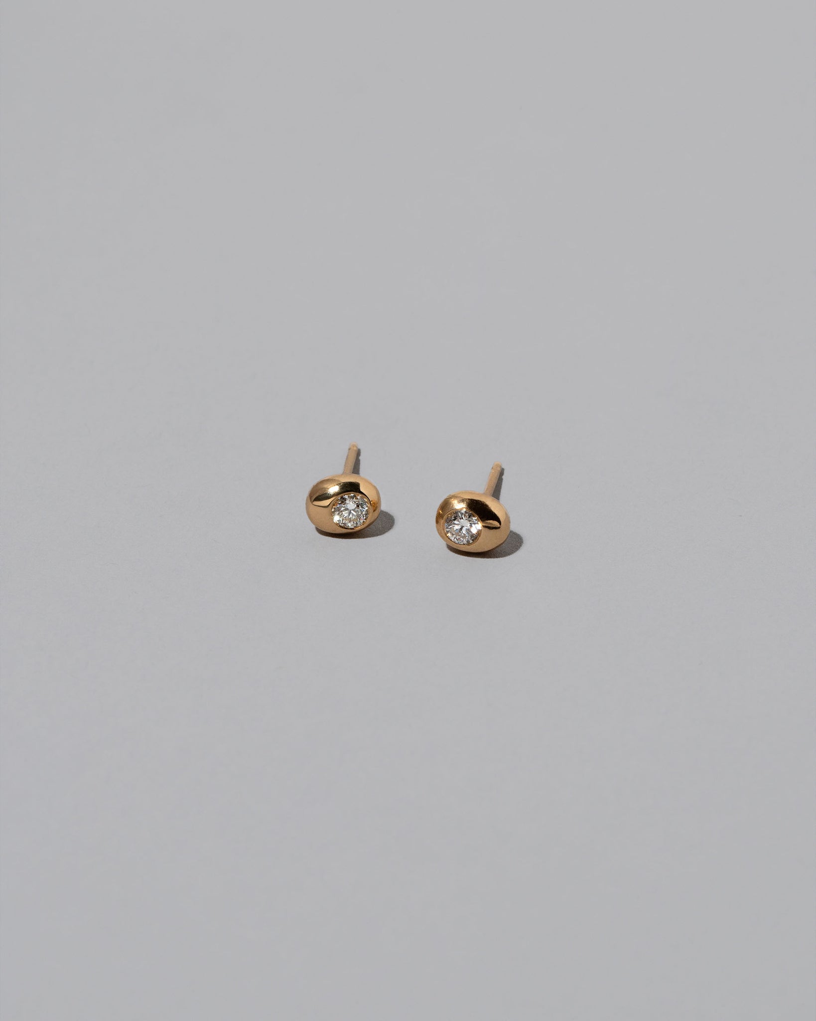Diamond Birthstone Level Stud Earrings on light color background.