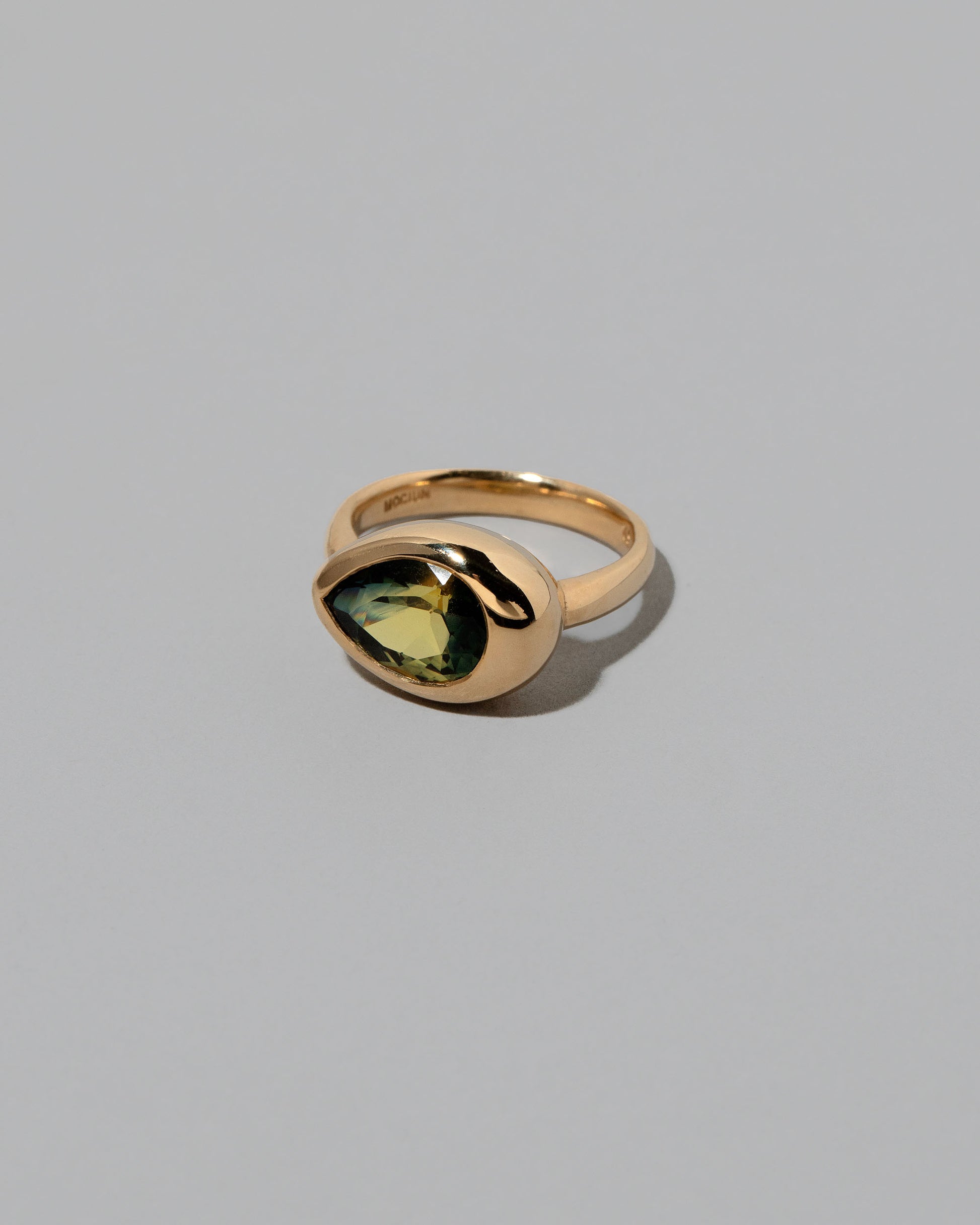 View from the side of the Bicolor Sapphire Grand Align Ring on light color background.