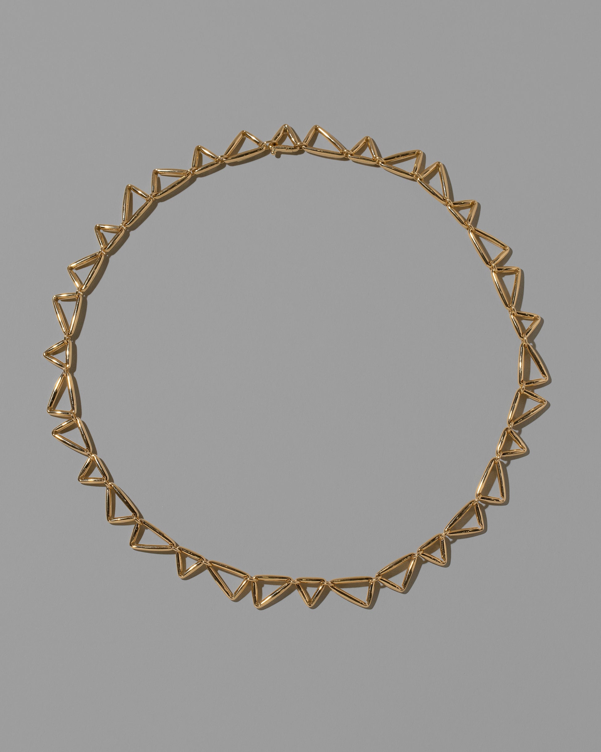 Gold Flexture Necklace on light color background.