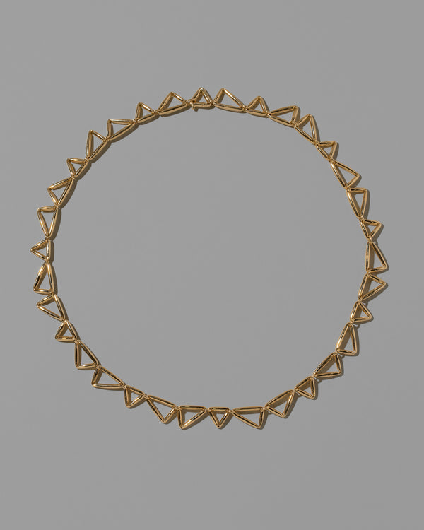 Gold Flexure Necklace on light color background.