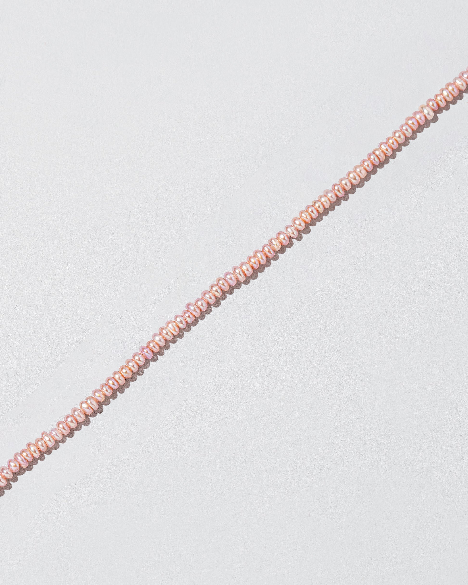 Closeup details of the Pink Lavender Seed Pearl Choker on light color background.