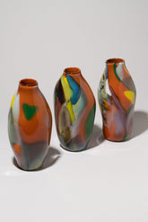 Group of BaleFire Glass Small Orange Epiphany Vases on light color background.